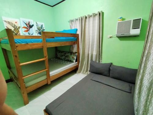 a room with two bunk beds and a couch at Urban Serenity Home in Puerto Princesa City