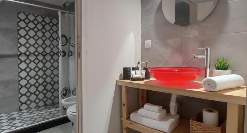 a bathroom with a red bowl on a counter next to a shower at Santa Relax in Frente Mar
