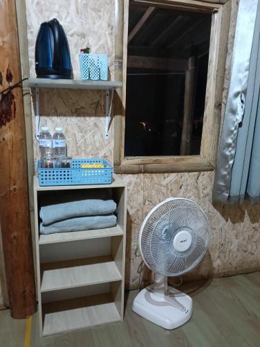 a bathroom with a fan and a shelf with towels at Chanya homestay in Ban Yang