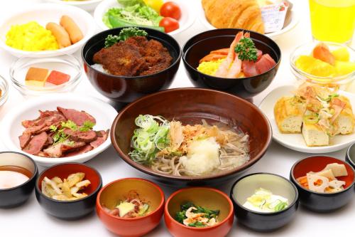 a group of bowls of food on a table at Dormy Inn Premium Fukui Natural Hot Spring in Fukui
