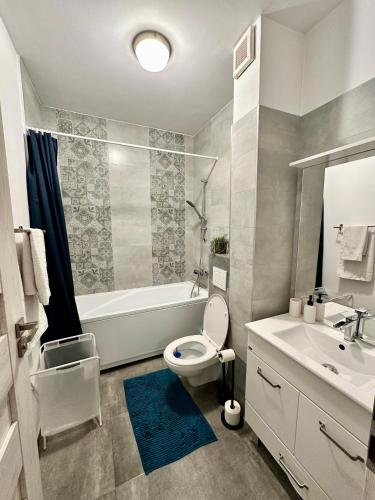 a bathroom with a toilet and a tub and a sink at Sunny View 2BR Apartment with Terrace - near VIVO and Amethyst in Floreşti