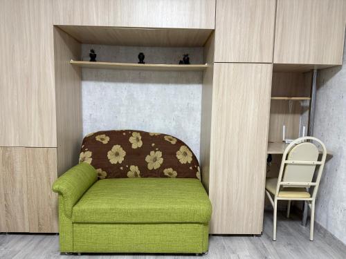 a green chair in a room with a desk at AeroHome Moldova- TAXI-PARKING ! in Chişinău
