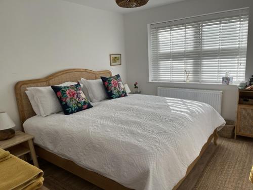 a bedroom with a white bed with pillows and a window at Retreat for Two in Shepton Mallet