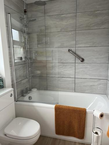 a bathroom with a tub and a toilet and a shower at Retreat for Two in Shepton Mallet