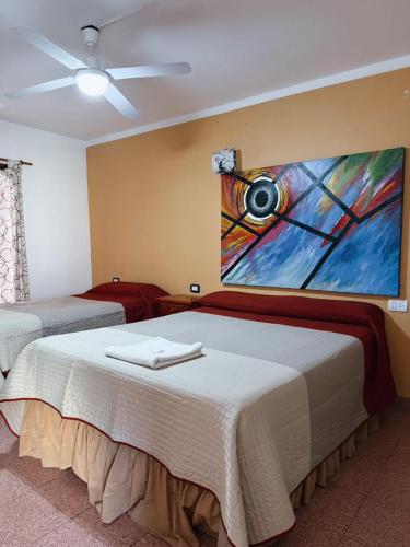 a bedroom with a bed with a painting on the wall at Petit Hotel Las Marias in La Rioja