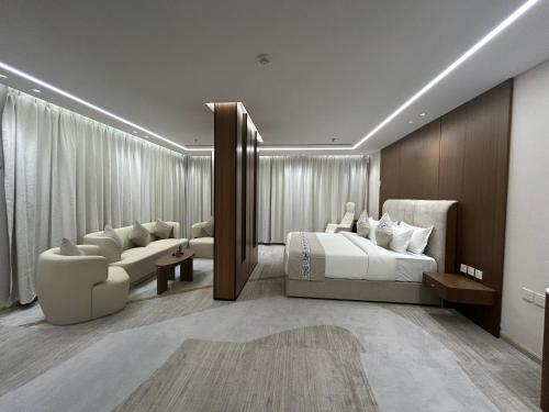 a hotel room with two beds and a couch at فندق سويت فيو in Al‘Āriḑah
