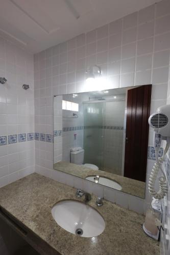 a bathroom with a sink and a mirror at Pousada Mirante dos Papagaios in Búzios