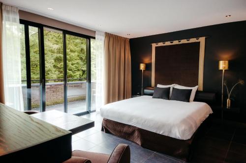 a bedroom with a bed and a large window at Hotel Gastronomique de Echoput in Apeldoorn