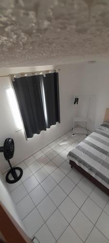 a bedroom with a bed and a black curtain at Ap no Turu, 10 min das praias in São Luís