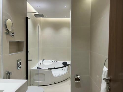 a bathroom with a bath tub and a toilet at فندق سويت فيو in Al‘Āriḑah