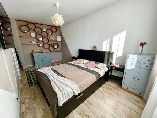 a bedroom with a large bed with pink pillows at Sunny View 2BR Apartment with Terrace - near VIVO and Amethyst in Floreşti