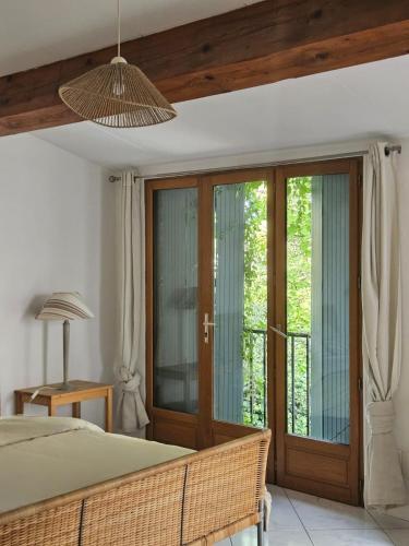 La Maison Cérétane في كريت: غرفة نوم بها سرير وأبواب زجاجية منزلقة