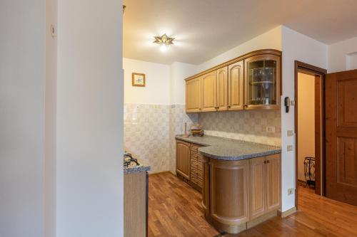 a kitchen with wooden cabinets and a counter top at Casa Tre Corone, sulla strada per Cortina in Borca di Cadore