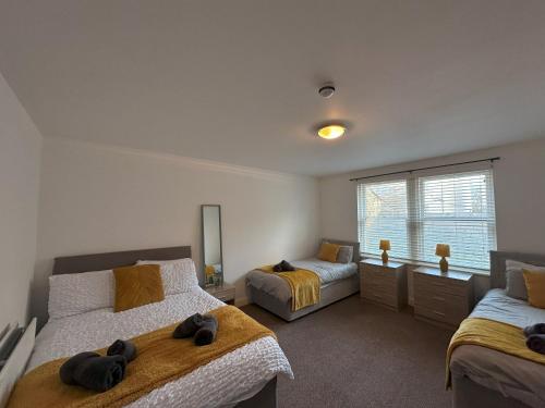 a bedroom with two beds and a window at Curwen Apartment - 2 Bedrooms - Sleeps 6 in Workington