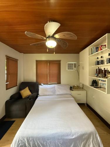 a bedroom with a bed and a ceiling fan at Villa with Beachfront Access in Lalauigan