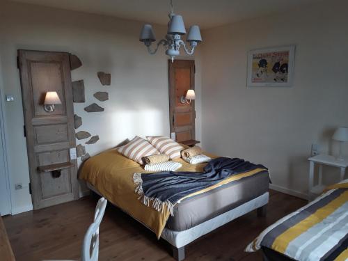 a bedroom with a bed with pillows on it at La Maison Bleue in Rosières
