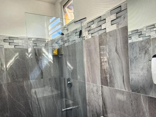 a bathroom with a shower with a glass door at Tropical Tobago in Riseland