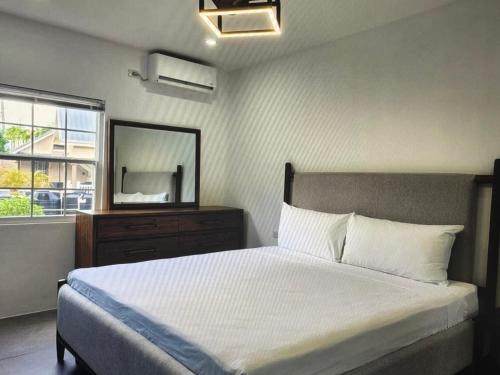 a bedroom with a large bed and a mirror at Tropical Tobago in Riseland