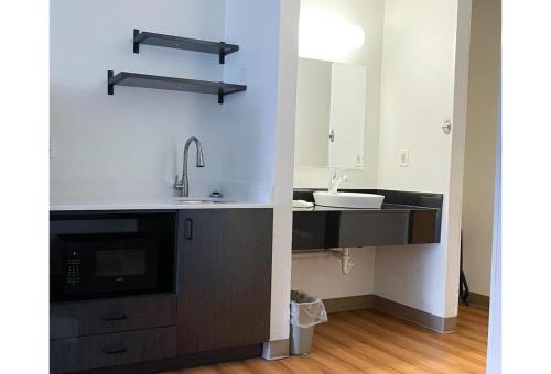 a kitchen with a sink and a microwave at Studio 6 Indianapolis, IN - Southport in Indianapolis