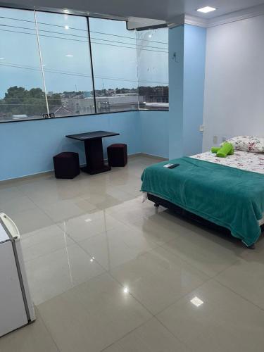 a bedroom with a bed and a table in a room at Quarto privado próximo ao centro 6 in Manaus