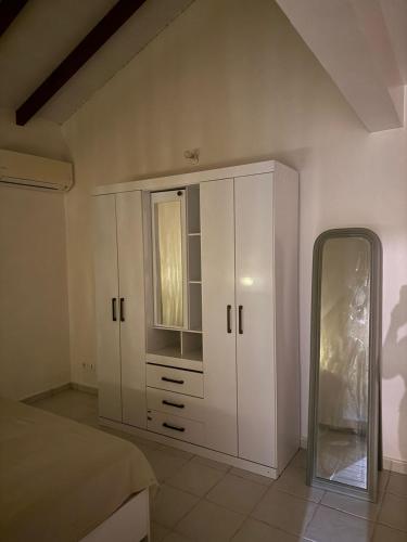 a bedroom with a white cabinet and a window at Villa Soleil des Caraïbes in Gourbeyre
