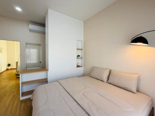 a white bedroom with a bed and a mirror at House in HangDong in Hang Dong