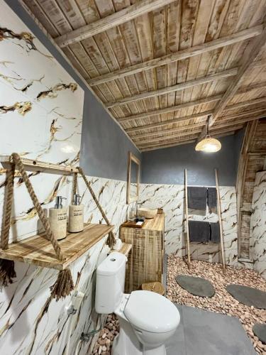 a bathroom with a white toilet in a room at Ratna's Green Hill Penida by Bali Cabin in Nusa Penida