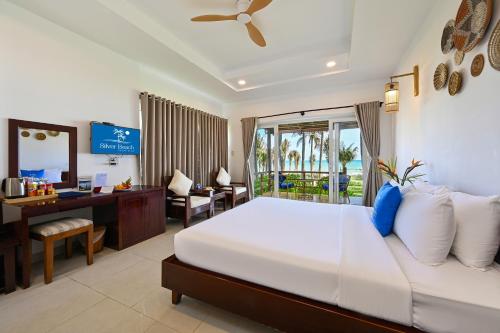 a hotel room with a bed and a desk and a computer at Silver Beach Resort Ke Ga in Ke Ga