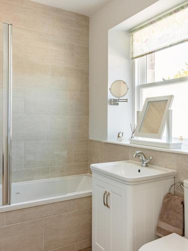 a bathroom with a tub and a sink and a shower at Lochburn Cottage in Elie