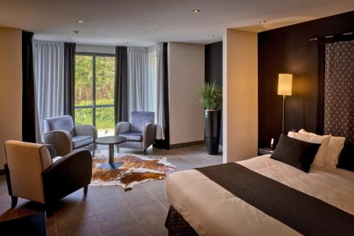 a hotel room with a bed and a desk and chairs at Hotel Gastronomique de Echoput in Apeldoorn