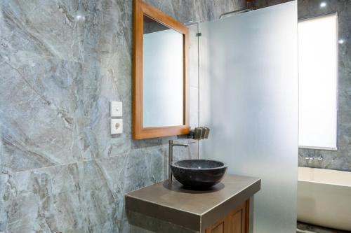 a bathroom with a sink and a mirror at Aditya House in Ubud