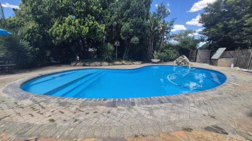a swimming pool in a backyard with a blue pool at Silhouette Guesthouse in Welkom