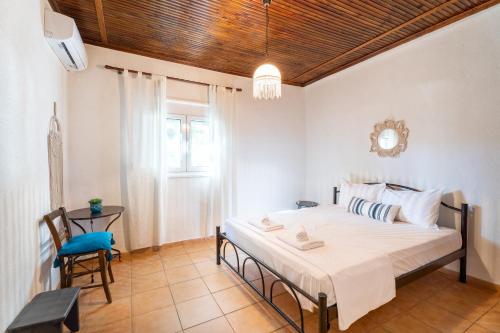 a bedroom with a bed and a table and a chair at Oasis Houses Maggana ,Xanthi in Mángana