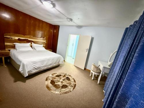 a bedroom with a bed and a table and a chair at Vimbainashe Villas in Umtali