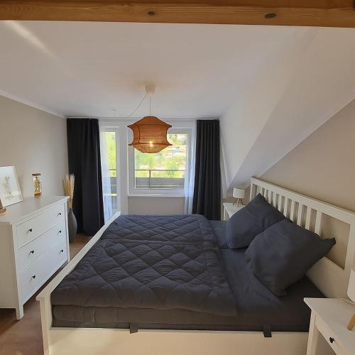 a bedroom with a blue bed and a window at Himmelsnest in Bad Wildbad