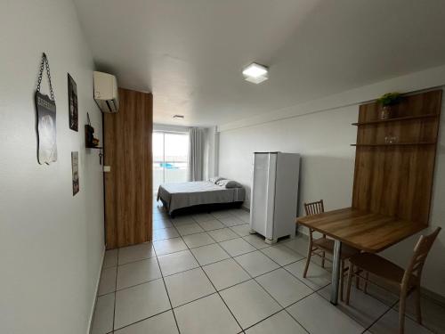 a room with a refrigerator and a table and a bed at Studio Easy West Flat in Mossoró