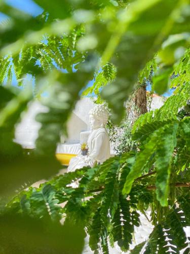 a statue of a monk sitting in a tree at The Eco Palace Hostel in Búzios