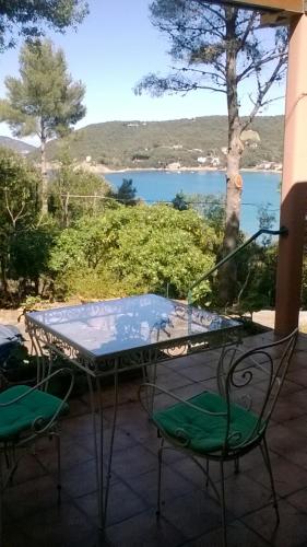 a table and chairs on a patio with a view of the water at Villa vista mare in Procchio