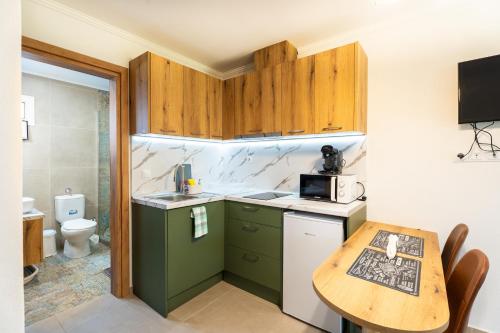 a small kitchen with a table and a sink at Oasis Houses Maggana ,Xanthi in Mángana