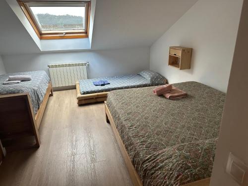 a bedroom with two beds and a window at Pilgrim’s House in O Pedrouzo
