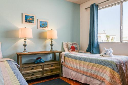 a bedroom with two beds and a window at Las Mareas #21 in Puerto Peñasco