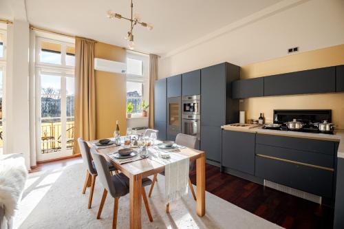 a kitchen with a table and chairs in a room at EDLER WOHNRAUM Design-Loft im Graphischen Viertel 2 Schlafzimmer mit Balkon, Miele-Kaffeevollautomat, Miele-Weinkühler, Klima, Lift, Tiefgarage & WLAN 266 Mbps in Leipzig