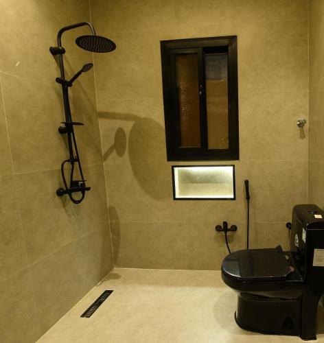 a bathroom with a toilet and a window at شقة مشراق in Al-ʿUla