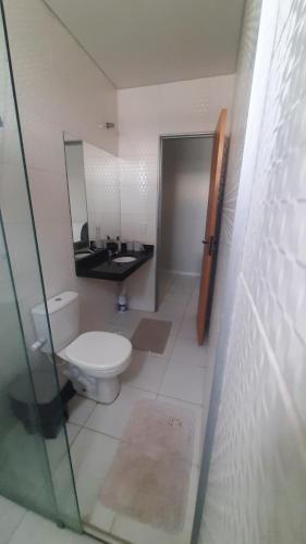 a bathroom with a toilet and a sink and a mirror at Apt 402 Ed Nilson Pimentel in Barreiras