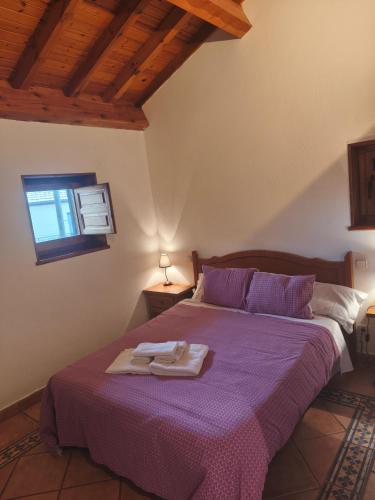 a bedroom with a purple bed with a tray on it at Posada de Serrada in Serrada de la Fuente
