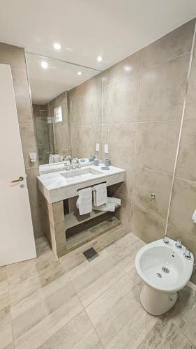 a bathroom with a sink and a toilet and a mirror at Suite de Lujo Castañitas in Tafí del Valle
