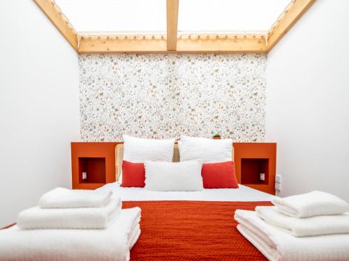 a bedroom with two beds with red and white pillows at Climatisé et atypique, bienvenue au LOFT-23 in Cholet