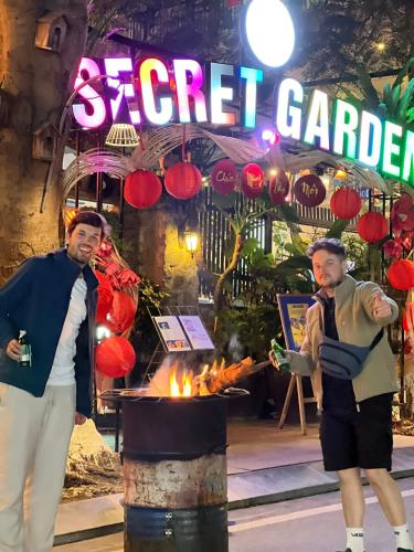 two men standing in front of a fire place at SECRET GARDEN Hostel - WANDERNEST Cat Ba in Cat Ba