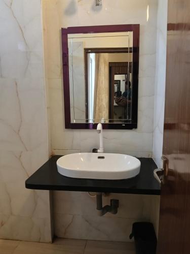 a bathroom with a sink and a mirror at Grand Milestone in Mysore