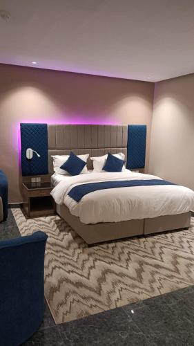 a bedroom with a large bed with a blue headboard at فندق بفنPuffin hotel in Qaryat al ‘Ulyā